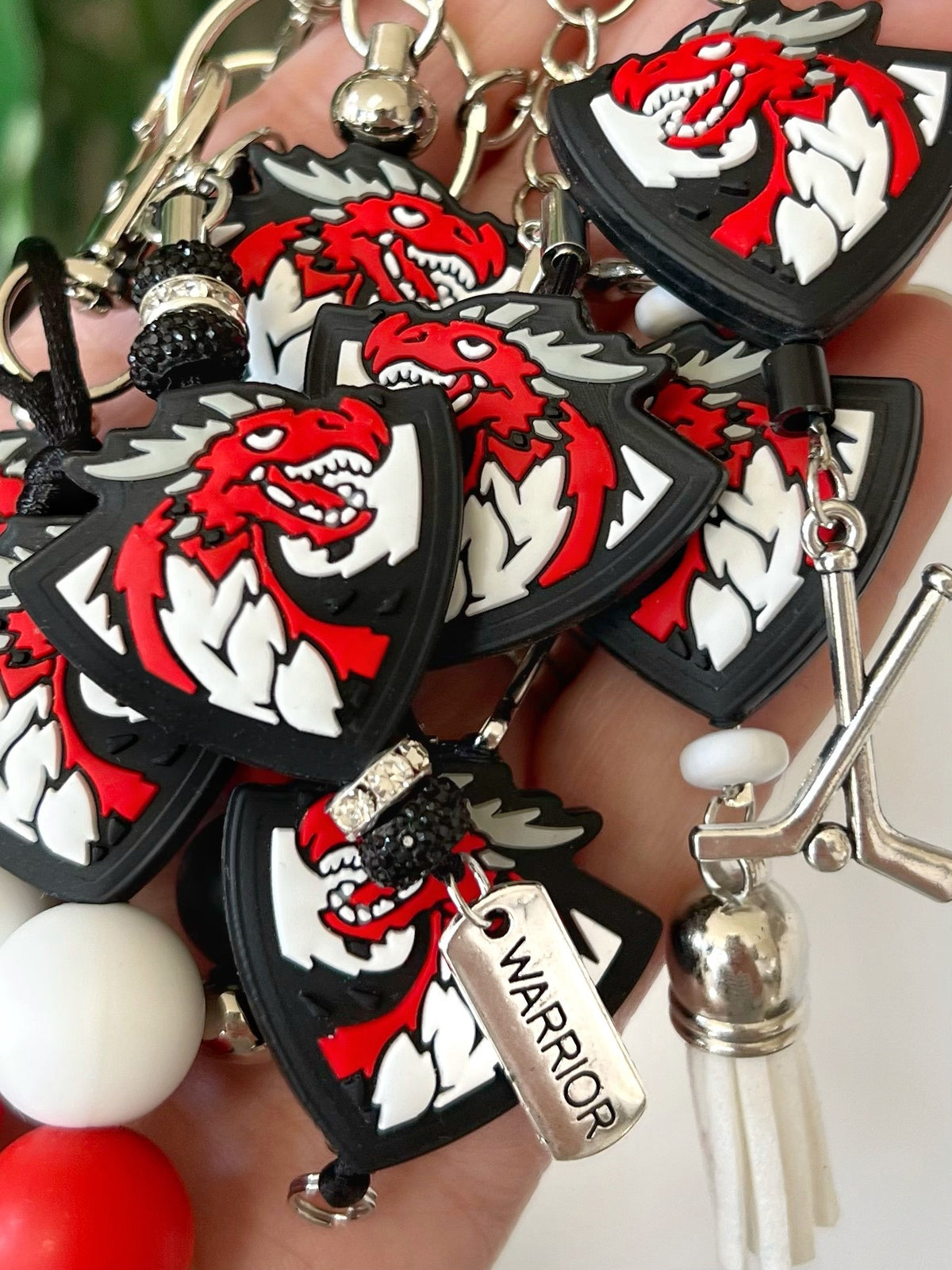 hand full of dragon keychains, charms, lanyards, zipper pulls, and backpack bookbag charms