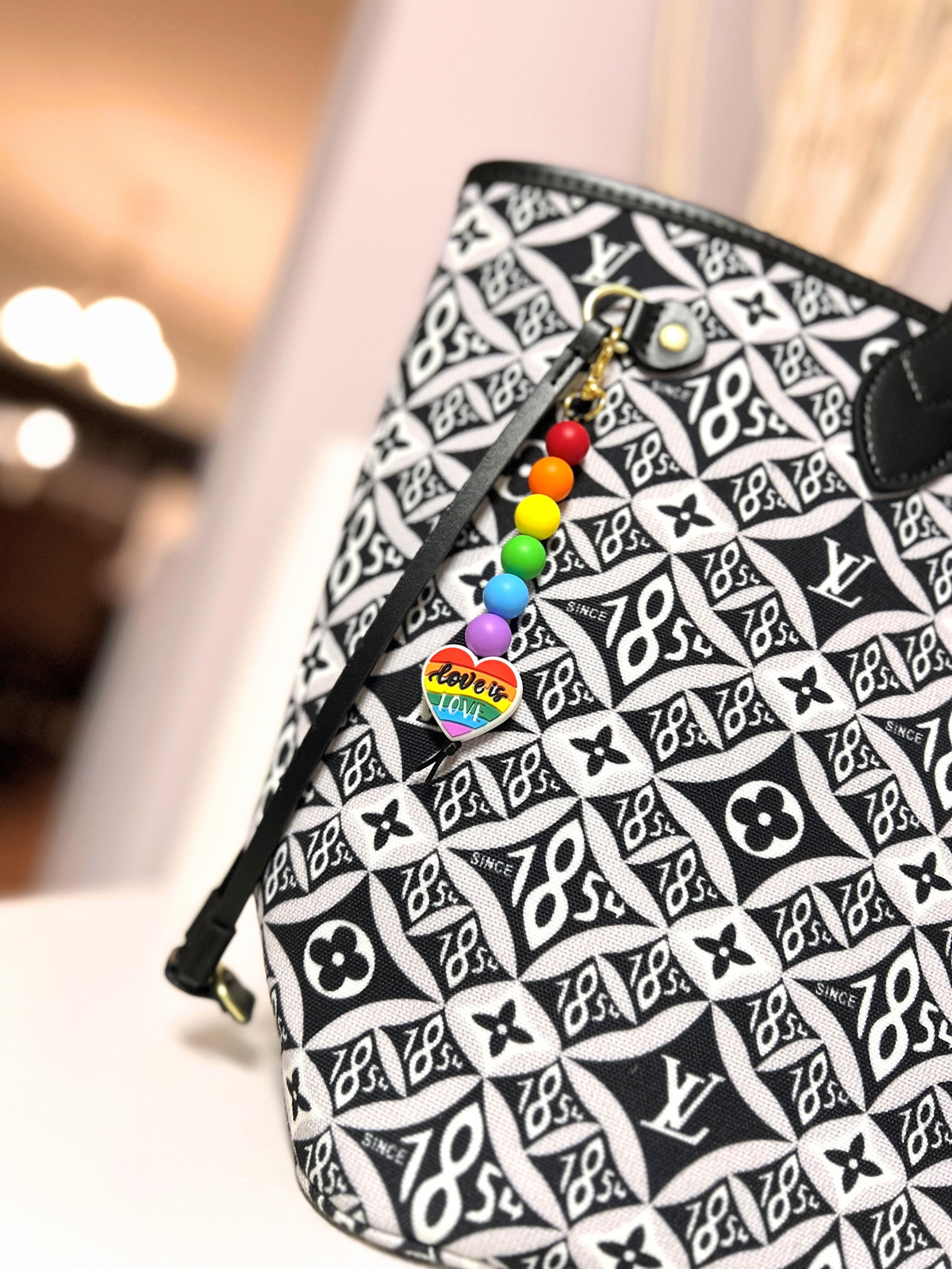 Louis Vuitton Bag with handmade Love is Love Silicone Rainbow Colored Bead Keychain hanging from it