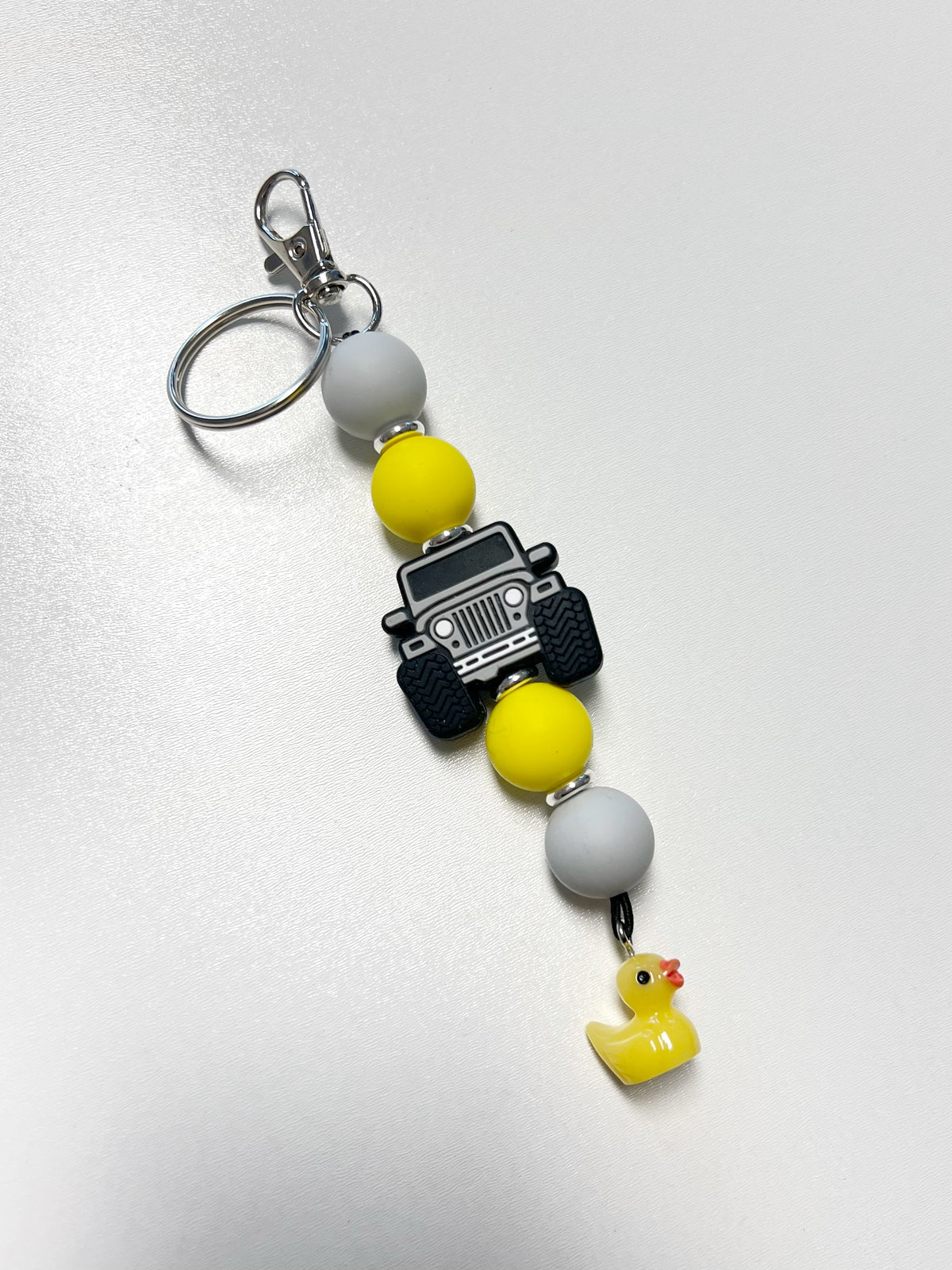 Durable handmade rubber duckie charm keychain with Jeep Wrangler 4x4 off-road vehicle in grey