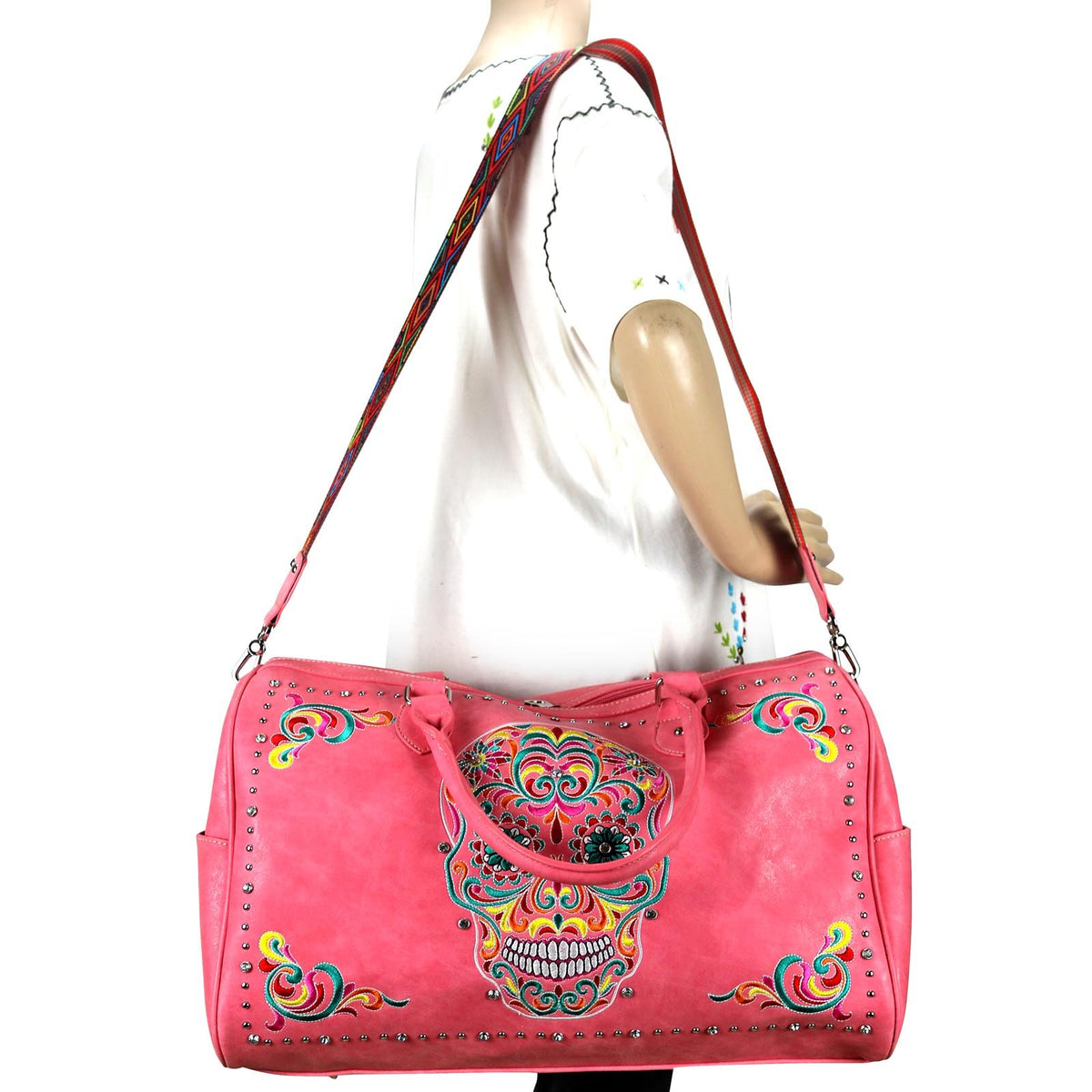 Want a Unique Duffle Bag? Take a look at our Embroidered Sugar Skull Duffle featuring a Vibrant Sugar Skull design accented with silver and crystal studs, top zipper closure, open button closure side pockets, interior zippered pocket and multiple open pockets, metal feet for protection and stability, detachable/adjustable shoulder strap, double handle, 20" x 8" x 12.5" dimensions. Gothic, Halloween, Punk, Alternative, Emo, Skull, Artistic, Unique, Statement Piece. 